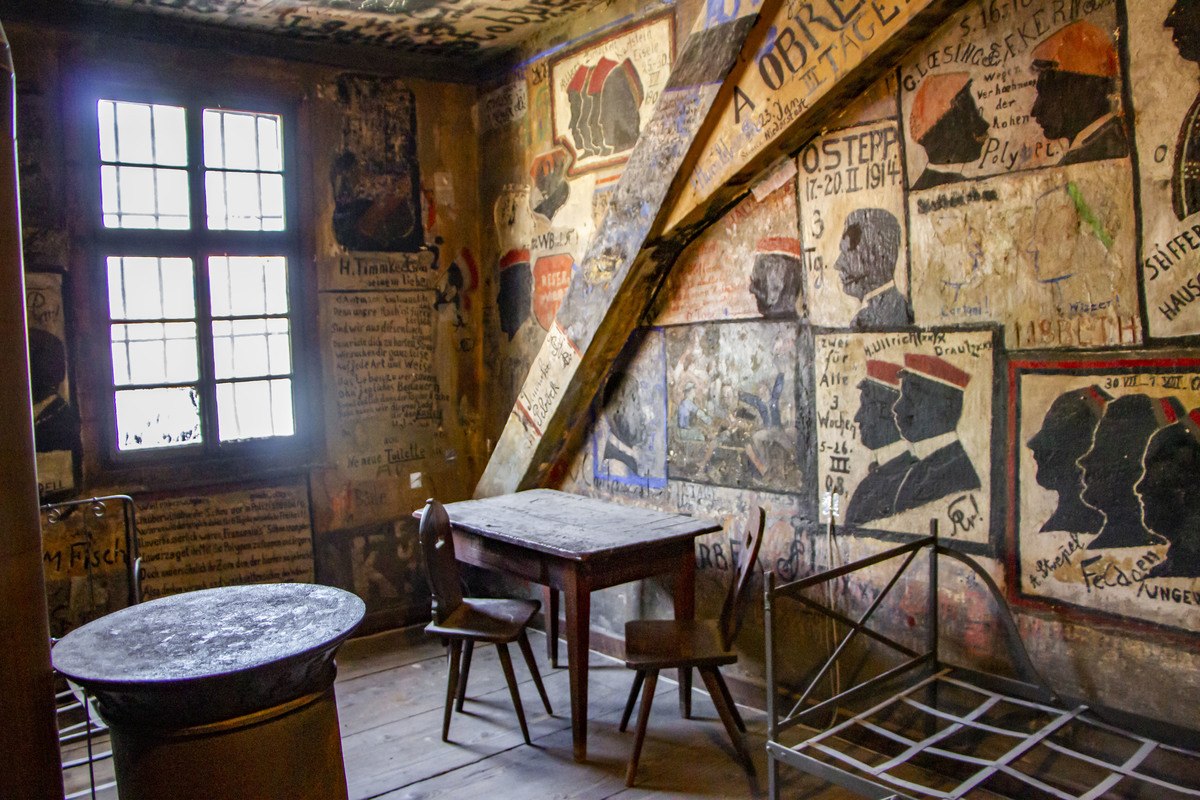Blick in ein Zimmer im Studentenkarzer mit Zeichnungen an der Wand